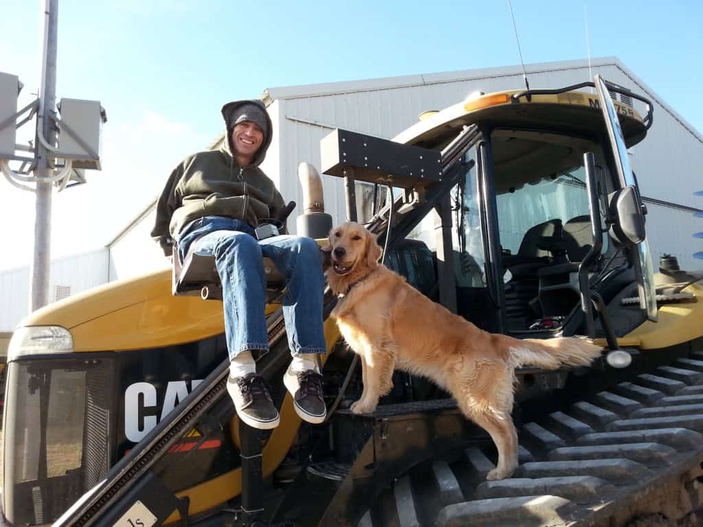 Farm equipment operator with dog on a CAT bulldozer at a farm. Farm equipment operator with dog on a CAT bulldozer at a farm.