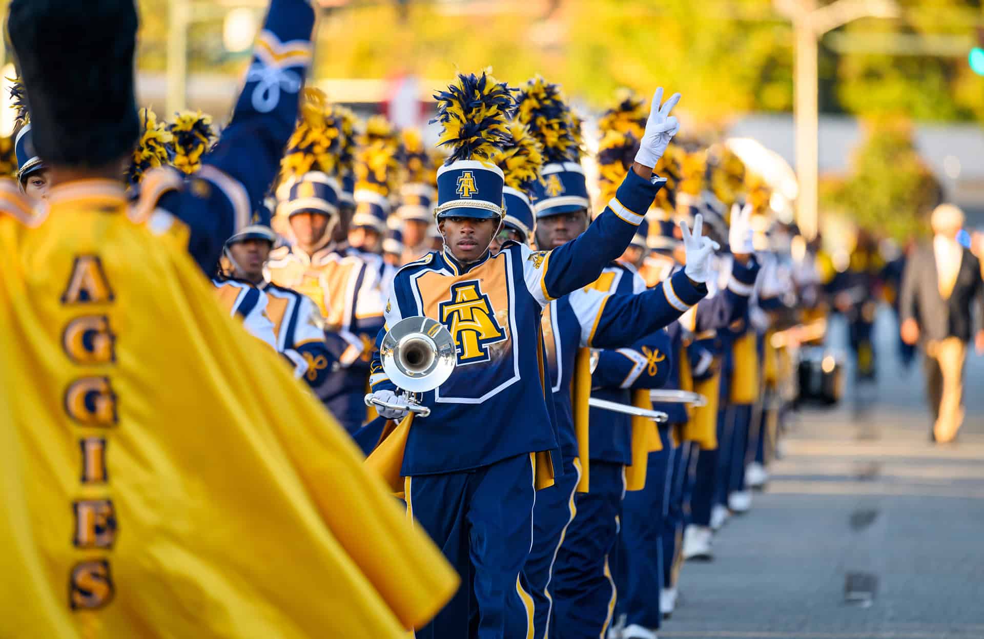 Marching band performance at a school event School marching band in uniform performing outdoors with instruments and colorful costumes.